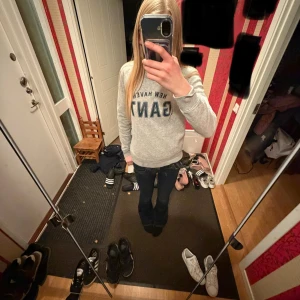 Grå sweatshirt från GANT - Säljer en stilren grå sweatshirt från GANT med trycket 'NEW HAVEN GANT' i mörkblått framtill. Tröjan har rund halsringning och långa ärmar 💕