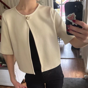 Beige kofta från Gina - Beige kofta från Gina tricot💕 den är ganska kort och har en gullig knapp framtill🩷 den är i strl M men passar bra på mig som vanligtvis har S/Xs