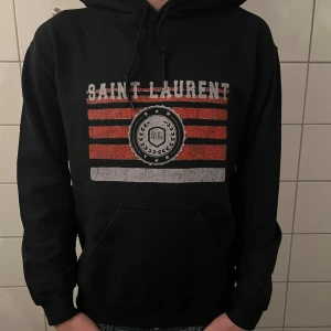 Saint Laurent hoodie - Riktigt fet och eftertraktad hoodie med saint laurent loggan. Storlek M, skick 10/10!! Modellen på bilden är 183cm. Saknar tag så är lite osäker på äktheten så därför är priset just nu på 999kr! Nypris runt 7000! Tveka inte med att ställa frågor!