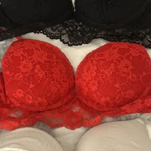 Röd spets bandeau tubtopp - Säljer en snygg röd bandeau tubtopp med blommig spets och vadderade kupor. Toppen är axelbandslös och har en bred spetskant nedtill som ger en extra fin detalj. Perfekt för att ge outfiten en färgklick och romantisk vibe.