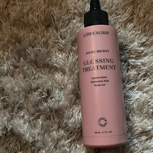 Löwengrip Shine Bright Glossing Treatment - Glossing Treatment från Löwengrip i en snygg rosa flaska med svart kork. Innehåller hyaluronsyra och ger direkt glans. Vegansk formula, 150 ml. Perfekt för dig som vill boosta hårets lyster med en lyxig känsla.