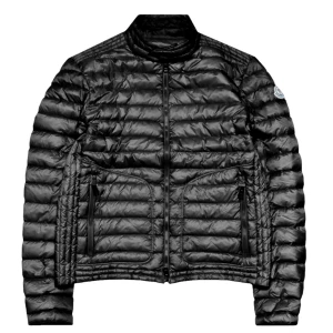 Svart dunjacka från Moncler - Säljer en svart dunjacka från Moncler med quiltad design och hög krage. Jackan har två stora fickor med dragkedja och en diskret Moncler-logga på ärmen. Perfekt för kalla dagar och har en stilren look som funkar till allt.