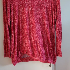 Röd leopardmönstrad långärmad tröja Esmara - Säljer en röd långärmad tröja från Esmara med leopardmönster i vitt och rosa. Tröjan har en loose passform och är tillverkad i mjuk polyester, perfekt för dig som gillar att sticka ut med färg och mönster. Superskön och chill vibe.