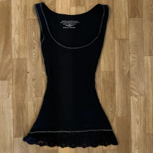 Svart y2k Linne med lace och silverdetaljer   - Svart linne från Esprit. Köpt second hand och är ursprungligen i storlek XL men har sytts in för att få en tight passform. Tyget är dock stretchigt, så jag skulle säga att det kan passa storlek L–S.