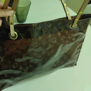 Brun genomskinlig väska. - Fin, brun väska i gott skick. Dock är ena handtaget trasigt. Går att laga hos skomakare eller så köper man nya remmar.