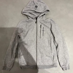 Grå hoodie från Sail Racing med dragkedja - Trendig sailracingjacka i toppen skick! Hör av dig för mer info!