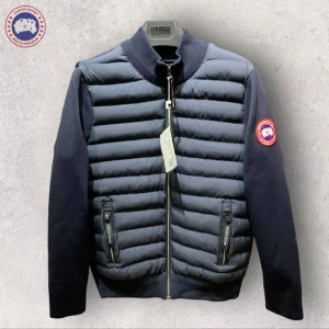 Mörkblå pufferjacka från Canada Goose - Snygg mörkblå pufferjacka från Canada Goose med quiltad framsida och släta ärmar. Jackan har dragkedja framtill, två fickor med dragkedja och ribbad krage. Perfekt för kyliga dagar och har en klassisk logga på ärmen.