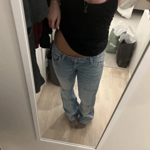 Ljusblå jeans med slitning - Säljer ett par ljusblå jeans med klassisk femficksdesign och en snygg slitning på ena benet, använt en gång men nu har dom blivit för stora 