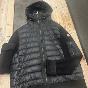 Cardigan  - En moncler cardigan i herr modell, jag vet inte om den är äkta men qr koden går att scanna så man kommer in på hemsidan. Storleken är Xl. Den är väl använd och dragkedjorna är lite rostiga. Den har inga skador men det syns att den är använd.