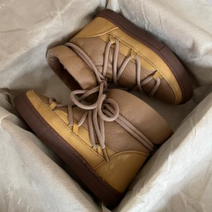 Gula Inuikii vinterskor  - Säljer dessa unika inuikii skor. Superfint skick (se sulans undersida). Endast små sprickor på vissa ställen på den gula lacken. Kolla in min profil för fler inuikii vinterskor.🙌