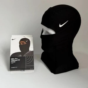 Nike Pro svart balaclava - Nike Pro Therma-FIT Hood är en svart balaclava med vit Nike-logga på sidan. Tight passform som täcker hela huvudet och halsen, lämnar bara ögonen fria. Tillverkad i mjuk och stretchig polyester för maximal komfort och värme.