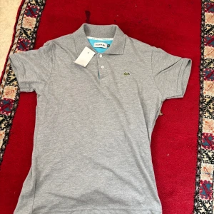 Lacoste pike - Säljer en sprillans ny Lacoste piké pga att den var för stor. Lappen finns kvar och nypriset ligger runt tusenlappen. Kan gå ner i pris vid snabb affär 💨 