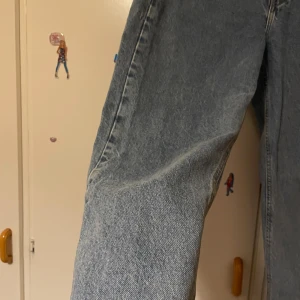 Ljusblå raka jeans med hög midja - Snygga ljusblå jeans med klassisk femficksdesign och hög midja. Jeansen har raka ben och är tillverkade i ett slitstarkt denimtyg. Perfekt för dig som gillar en clean och tidlös look. Passar till sneakers eller boots.