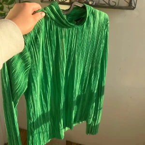 Grön Blus - Snygg grön blus med silkes liknande tyg och omlott-design. Blusen har lång ärm, och två små knappar i bak. Jag personligen använt den bakfram och vikt in knapparna som jag visar på sista bilden. Så du vet innan den är inte så stretchig. Den är S men passar M oxå💕