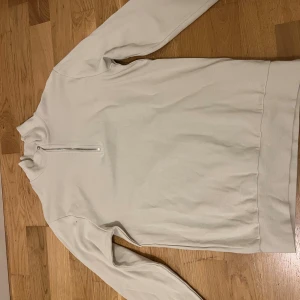 Beige half zip sweatshirt - Snygg beige sweatshirt med half zip framtill och hög krage. Tröjan har långärmade ärmar och är tillverkad i mjukt bomullsmaterial. Enkel och clean design som funkar till många olika stilar. Perfekt för dig som gillar neutrala färger och bekväma plagg.