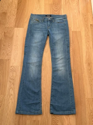 Blå bootcut jeans från Killah - Snygga blå lågmidjade bootcut jeans från Killah, tillverkade i mjukt denimtyg som sitter skönt och ger en avslappnad look. Storlek 27 💕
