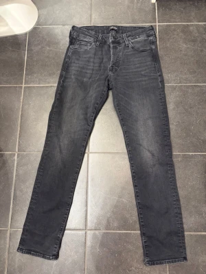 Svarta slim jeans från Jack & Jones - Säljer ett par svarta slim fit jeans från Jack & Jones, modell slim Glenn. Jeansen har klassisk femficksdesign, normal midja och raka ben med en smal passform. Materialet är mjukt och stretchigt jeans-tyg som sitter snyggt hela dagen.