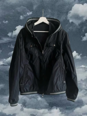 Moncler windbreaker  -  Moncler Windbreaker i modellen Jeansclaude giubbotto i storlek 2 vilket motsvarar S/M skick 8/10 då den har ett litet hål i ärmen allt og givetvis äkta 