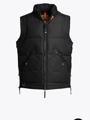 Svart dunväst från Parajumpers - Säljer en svart dunväst från Parajumpers med hög krage och två stora fickor framtill. Västen har dragkedja hela vägen och coola detaljer som orange flärp vid halsen. Perfekt för lager-på-lager och riktigt snygg till streetwear.v