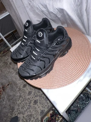 Nike Tn  - Säljer ett par helsvarta Nike Air Max sneakers med mesh och syntetdetaljer. Skorna har snörning, rund tå och en chunky sula med synlig Air-enhet. Perfekta för dig som gillar sportig och clean stil. Diskret Nike Air-logga på plösen. Pris kan diskuteras!