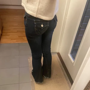 Low waist True Religion Jeans - Säljer mina true religion jeans eftersom de är lite för stora för mig.                                            Modellen heter Joey flare och är färgen är mörkblå. Jag köpte jeansen från Tara för ca ett halvår sen och de är i fortfarande i bra skick💕. De har  slitnad längst ner vid hälarna (se bild 2 & 3), utöver det är de så gott som nya.  Nypris: 1300kr                                                                           Midjemått (tvärs över): 38cm              Innerbenslängd: 83cm