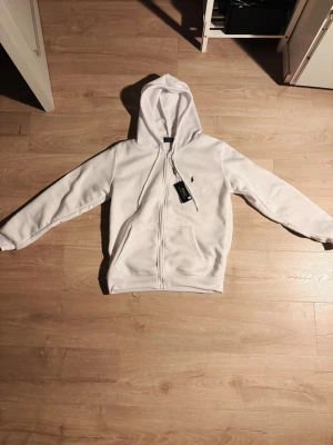 Vit zip-up tröja från Ralph Lauren - Varm och skön zip up tröja från Ralph lauren. Perfekt nu för vintern och är en fin tröja. Storlek S Den är helt ny