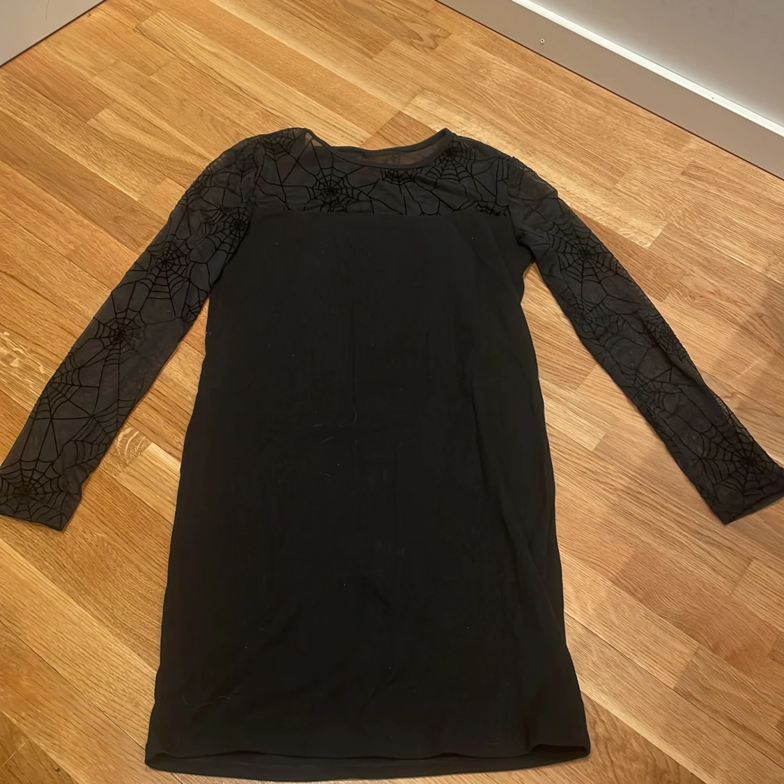 Svart klänning med spindelnätsmönster