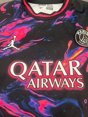 PSG Mbappé matchtröja Nike - Beskrivning: Säljer en riktigt snygg Paris Saint-Germain (PSG) matchtröja från Jordan/Nike. Tröjan är i nyskick, använd väldigt lite.  🔹 Spelare: Mbappé #7 🔹 Lag: Paris Saint-Germain (PSG) 🔹 Märke: Jordan / Nike 🔹 Storlek: 164 (barn) 🔹 Färg/design: Svart med färgstarkt mönster 🔹 Sponsor: Qatar Airways / Ooredoo  Inga fläckar, hål eller slitage – ser nästan oanvänd ut. Perfekt för PSG-fan, träning eller vardag.