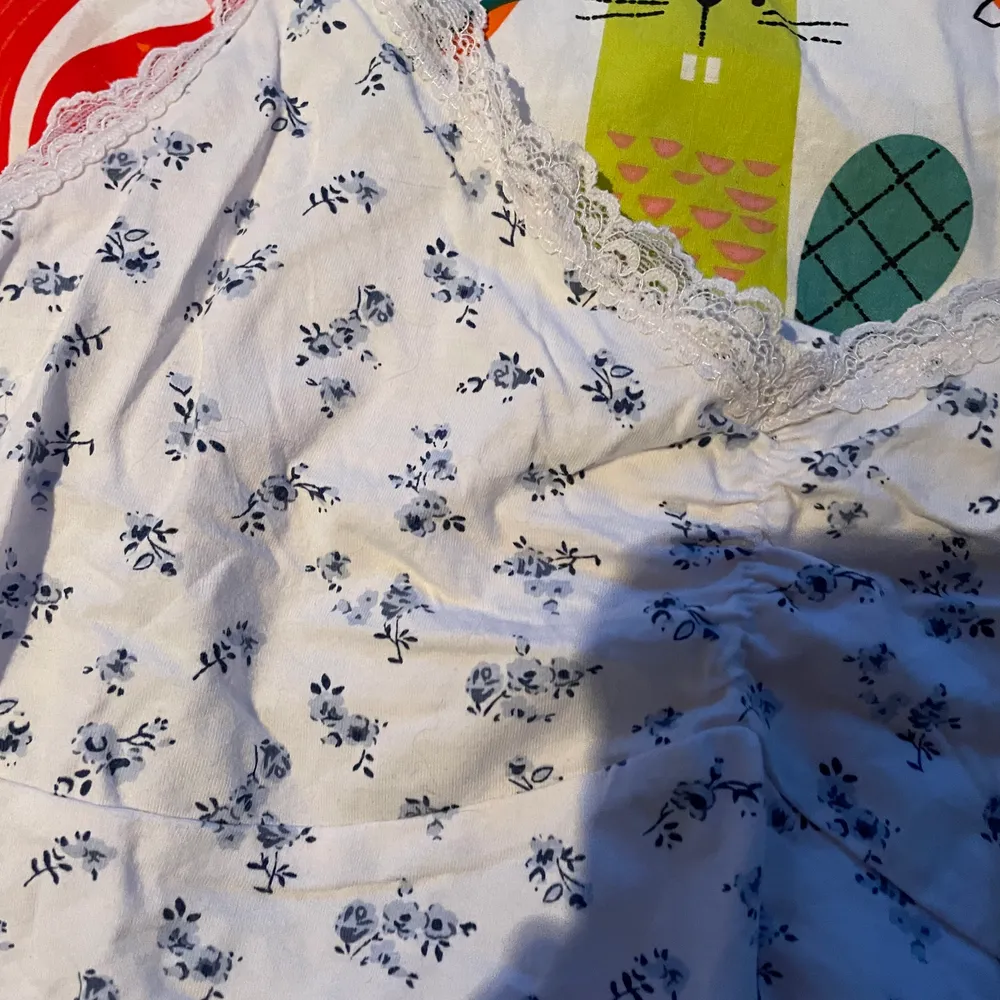 Ett vitt linn/croptop med blåa blommor, jättesöt på sommaren med kjol annars bara skön att ha hemma. Toppar.