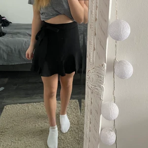 Svart volangkjol - Superfin svart volangkjol från NA-KD!! Band i midjan som går att knyta var som helst. Storlek 36 och perfekt längd för mig som är 170 cm. 50kr + frakt ❤️