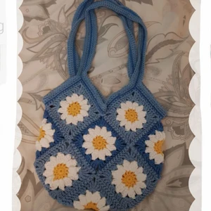 Granny square väska - Blå  - Granny square väska gjord i bomull och akrylgarn. Så fin och piffar upp vilken outfit som helst❣ Väskan är ca 28 cm i bredd och ca 27 cm i längd. Räknar man med axelremmen är väskan 57 cm i längd totalt💙🌼 (Lång axelremm) (Frakt ej inräknad i priset)