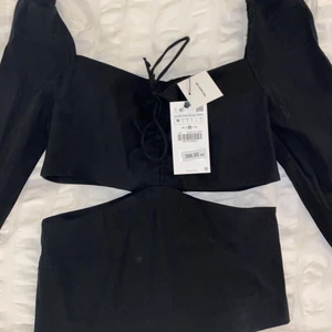 Zara topp - Svart topp från Zara med cut out, storlek M (passar även S). Helt oanvänd med prislapp kvar, endast testad. Köpt för 399kr. Köparen står för frakten!
