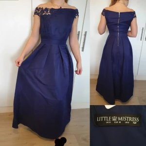 Balklänning offshoulder marinblå - Balklänning med detaljerad offsoulder band från ASOS. Klänningen är aldrig använd. Kan mötas upp och frakta. Storlek 38. Kvinnan på bilden är 172 cm. 