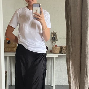 Svart långkjol från Vero Moda - Denna ursnygga och eleganta kjolen är en aning för stor för mig i midjan och måste tyvärr säljas! ”Krullet” går att reglera med två snören. Kjolen är ALDRIG använd!