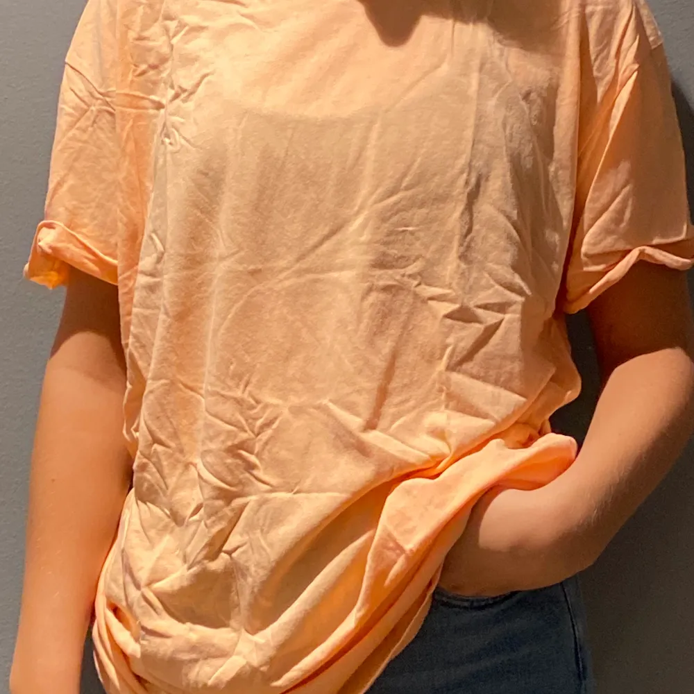 En stor t-shirt från herravdelningen i en väldigt somrig och härlig orange färg, väldigt tunn. T-shirts.
