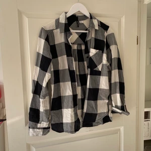 Flanell skjorta  - En väldigt skön flanell skjorta. Den har krage och knappar i armarna och en ficka på vänstersida vid bröstet. Väldigt mjuk i materialet. Använd fåtal gånger