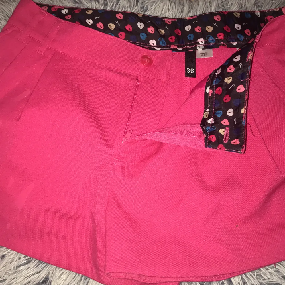 Rosa shorts i finare material. Fickor finns både fram och bak; de bak är fortfarande ihopsydda (kan sprättas upp).  Nästan helt oanvända. . Shorts.