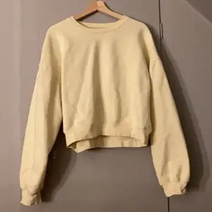 En gul sweatshirt i storlek M ifrån Bikbok. 