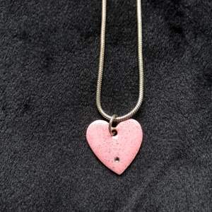 Halsband med ett rosa hjärta. På bild nr 2 ser ni den ungefärliga längden. Säljes till den som lagt det högsta budet i kommentarsfältet. Porto på 13 kr tillkommer (inte 24kr som står i annonsen)