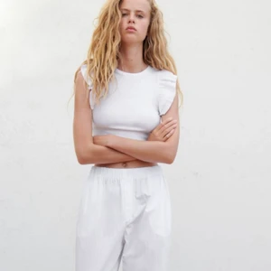 Tröja med volanger - Super snygg vit tröja med volanger från ZARA i storlek  S. Anledning till att jag säljer den är för att den aldrig kommer till användning. Original priset är 99 kr.