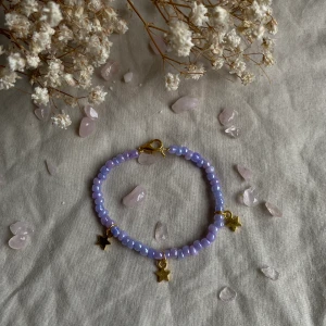 Armband  - Armband med sjärnor denna är i en lila färg med guld detaljer !💗  frakt tillkommer 14kr