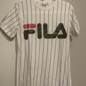 Fila T-shirt st S - Super fin och nästan som ny, men efter att ha tvättat den så märkte jag att den har fått som en missfärgning av texten, på baksidan! Se bild! Priset är inkl frakt! 