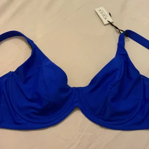 Ivory rose bikini - En super super snygg bikini överdel i en kobolt blå färg från Ivory Rose, köpt på asos. Säljer pga av att den är för liten. Det står att det är en 38E/80F men den absolut inte så stor och de ser man på bilderna med. Skulle säga en 80C eller en 80D. Helt oanvändbar, ensdast testad 1 gång, lappen sitter kvar.( pris kan diskuteras)