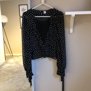Fin blus med volanger - En superfin blus som är svart med små vita prickar på. Volanger och ärmar med snören❤️