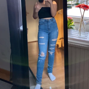 Ripped skinny jeans - Blå skinny jeans med hål. Köpta på HM. Använder ej denna typ av jeans längre, därav säljer jag dem. Lite långa på mig som är 157 cm lång, därför blekta smutsfläckar längst ner vid sömmen, något som man inte tänker på/ser om man viker upp kanten. Frakt ingår ej i priset.