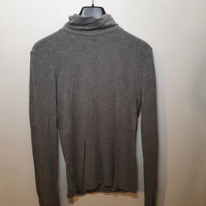Tröja med polokrage - Säljer en tröja med polokrage i färgen grå. Tröjan är I nyttskick och har en oversized passform och är i storlek L. Mitt pris: 75kr.