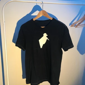 T-Shirt - Mörkblå t-shirt med tryck i storlek small. Mönster i tröjan syns på andra bilden, trycket sitter på framsidan.