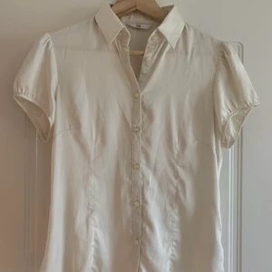 Vit kortärmad skjorta - Kortärmad vit skjorta/blus från H&M i silkigt tyg (polyester).
