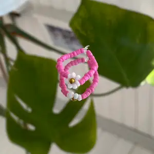 Rosa ring med blomma, egentillverkad! 💗                   Passar S-M                                                                         Säljer för 15kr + 12kr i frakt. Fraktpriset är det samma oavsett antalet ringar man köper ✨