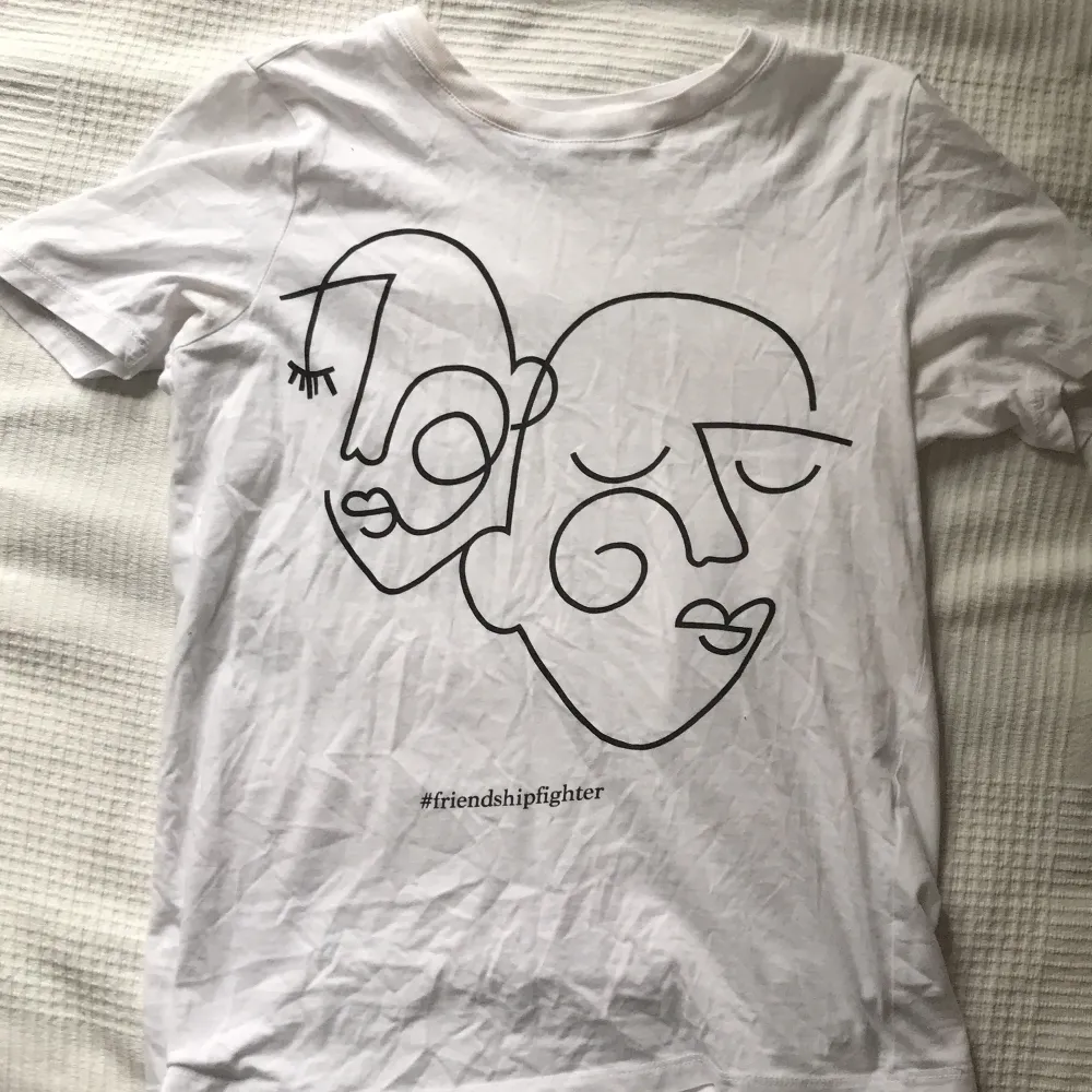 En vit t-shirt med 2 ansiktsuttryck på! Citat: #friendshipfighter💖💖 Använd några få gånger! Väldigt fin! Finns EJ kvar i butik. T-shirts.